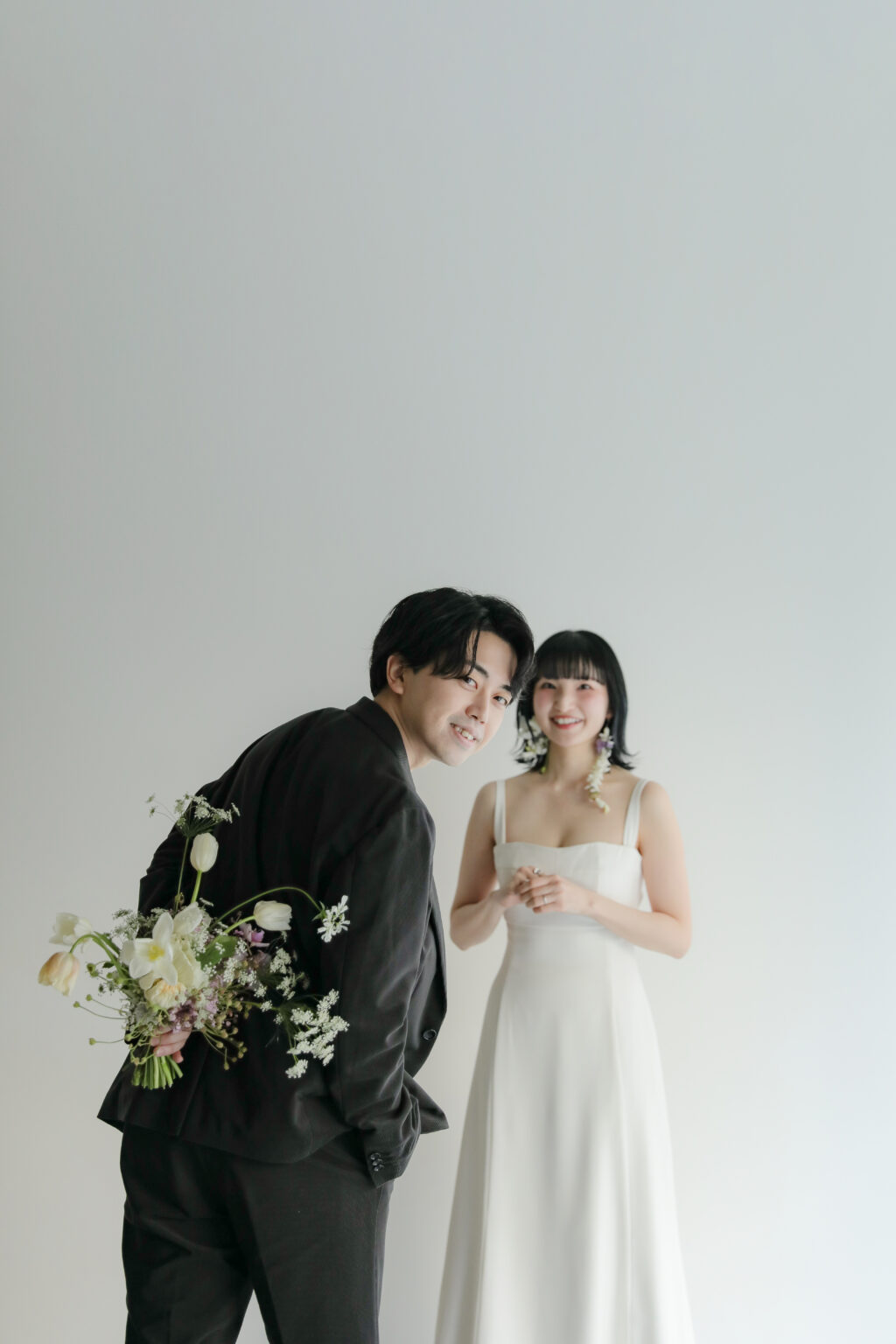 白壁のシンプルなスタジオで撮影された、洗練された洋装のウエディングフォト・前撮り| IN MY LIFE photography
