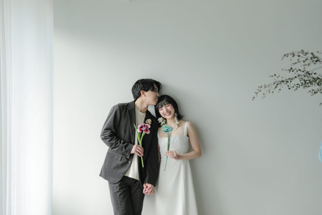 白壁のシンプルなスタジオで撮影された、洗練された洋装のウエディングフォト・前撮り| IN MY LIFE photography