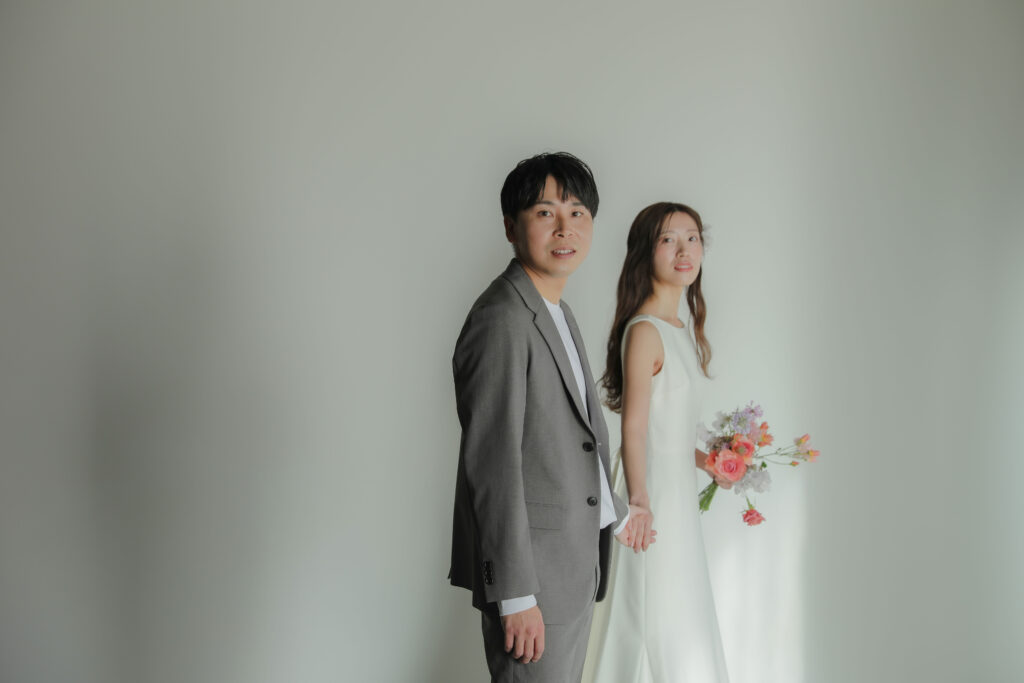 白壁のシンプルなスタジオで撮影された、洗練された洋装のウエディングフォト・前撮り|
IN MY LIFE photography