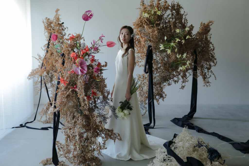フォトスタジオの白を基調とした空間に飾られた、鮮やかな花とのフラワーベースのスタ
イリング| IN MY LIFE photography