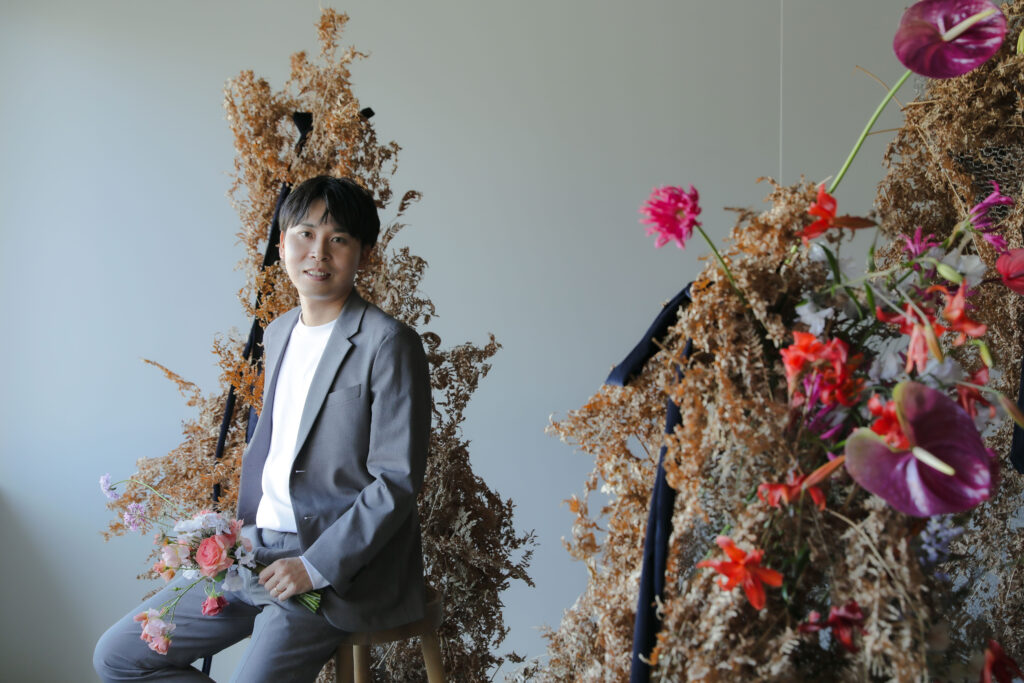 フォトスタジオの白を基調とした空間に飾られた、鮮やかな花とのフラワーベースのスタ
イリング| IN MY LIFE photography