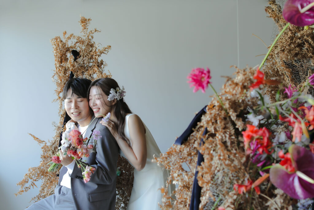 フォトスタジオの白を基調とした空間に飾られた、鮮やかな花とのフラワーベースのスタ
イリング| IN MY LIFE photography